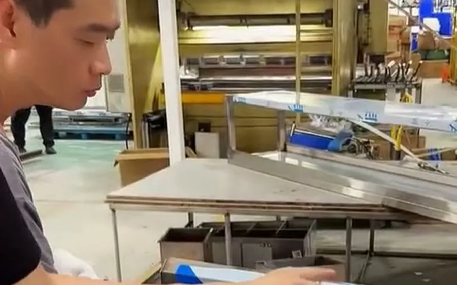 Worker welding stainless steel kitchen equipment in factory