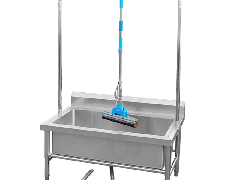 Mop sink with mop hanging on the rail