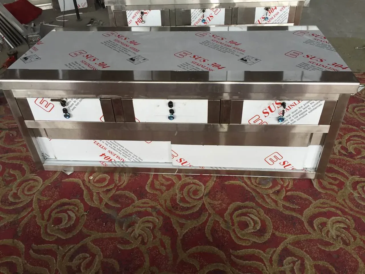 Side view of a stainless steel work table showing the top, frame and leg structure