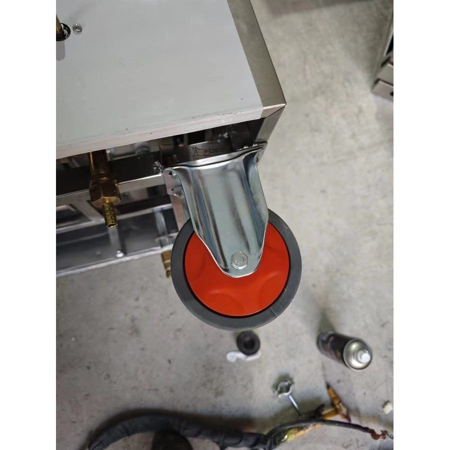 Close-up of heavy-duty rubber caster with brake and stainless mounting bracket on a Full Kitchen rice steamer